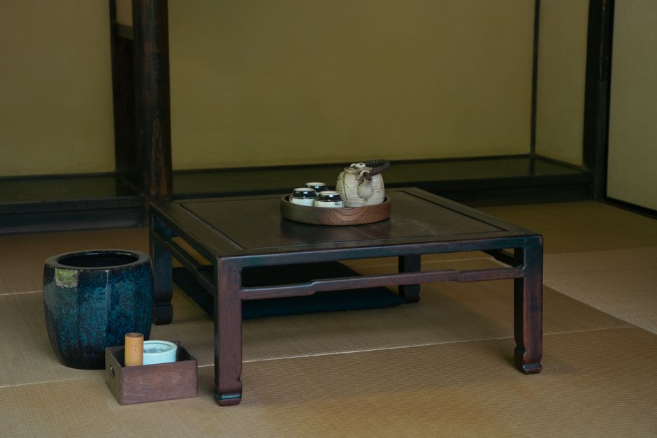 A serene Japanese tatami room featuring a wooden table with a tea set, perfect for cultural exploration.