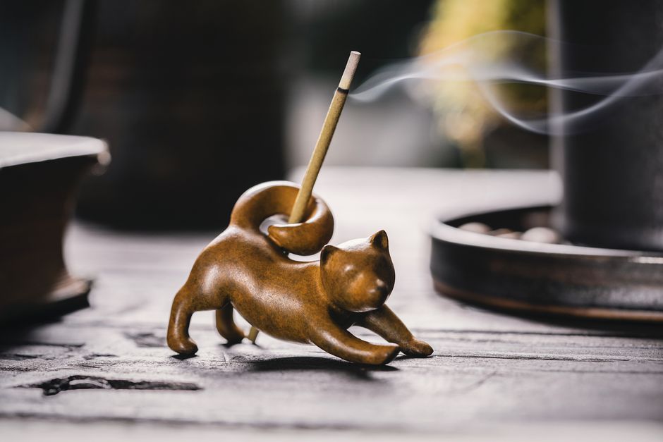 A beautifully crafted fox-shaped incense holder with smoke rising on a wooden table. Perfect for home decor.